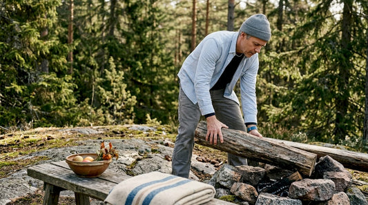 En man dukar upp ett trädgårdsbord på en norrländsk altan