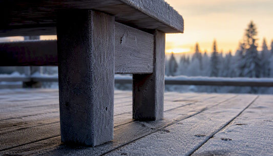 Närbild på robusta trämöbler ute på en snötäckt altan.