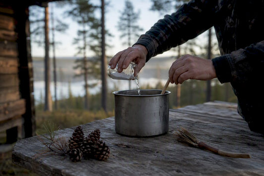Händer som rör om järnsulfatlösning för träbehandling